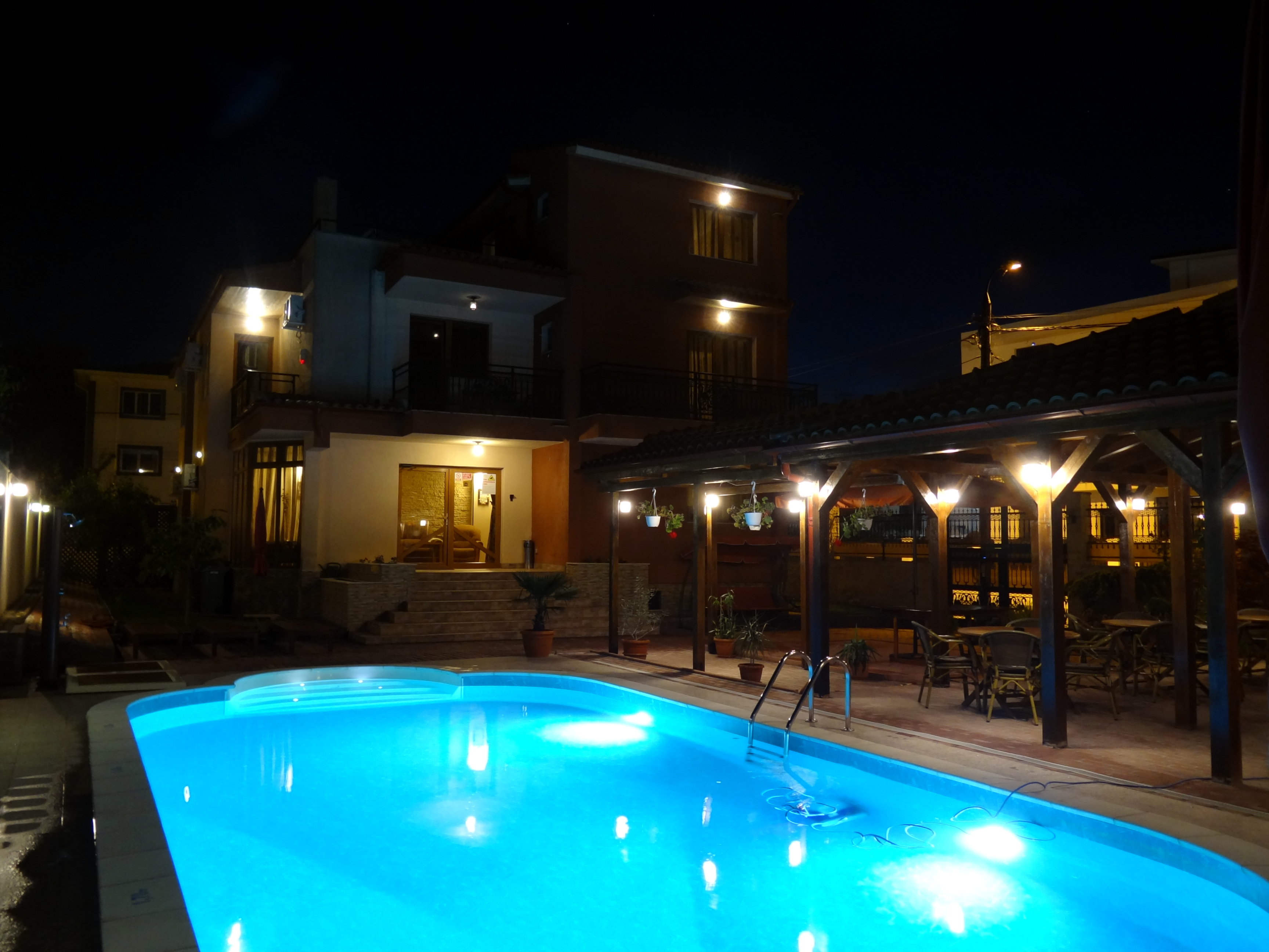 Piscina, vedere nocturna cu vila si terasa in fundal